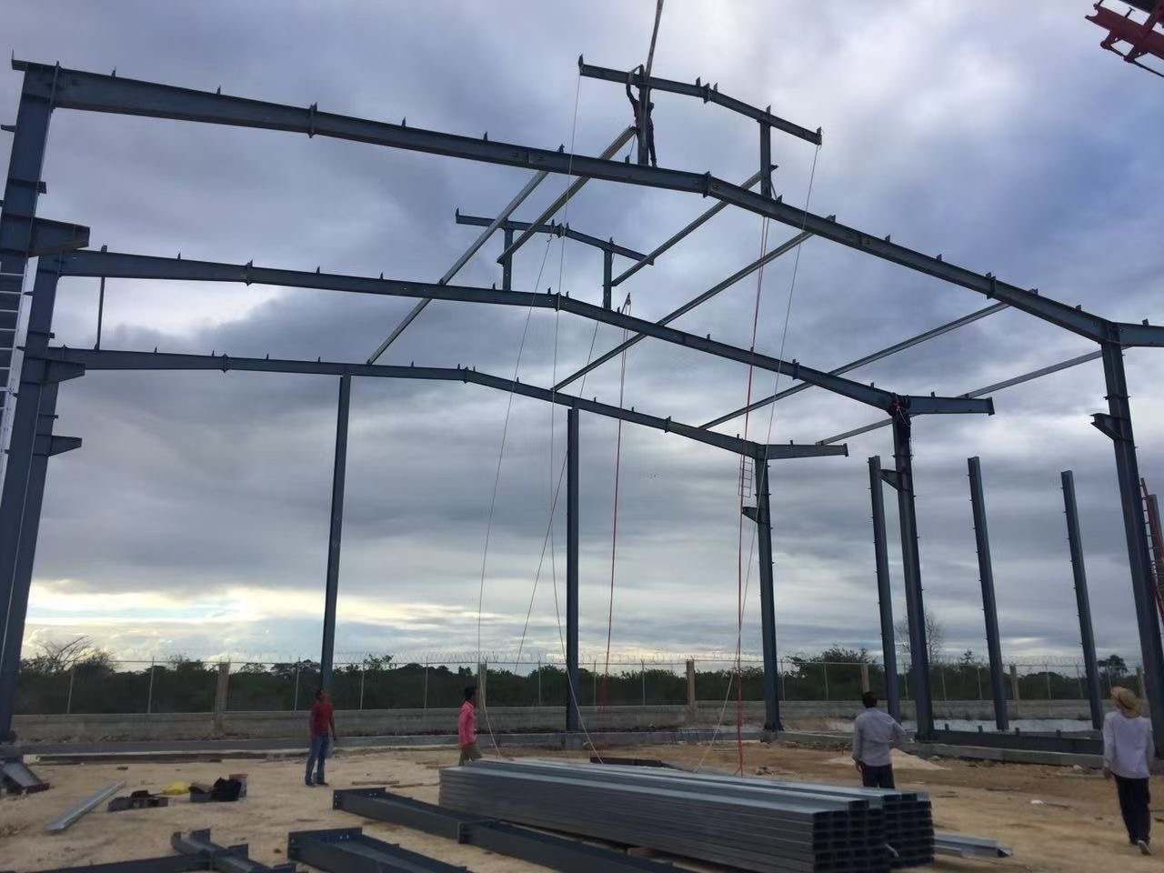 A row of erected steel portal frames on a site, before cladding is fixed.